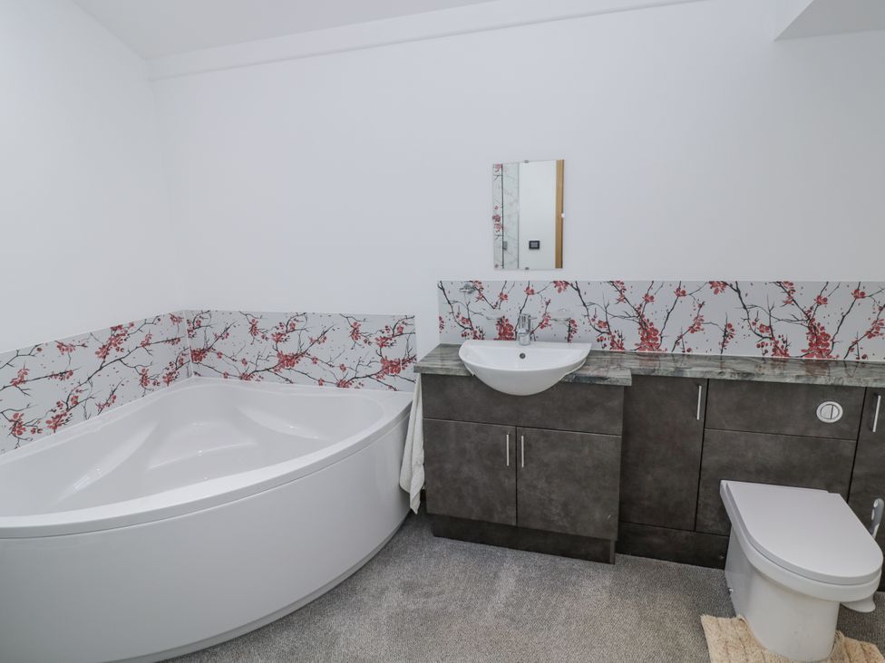A bathroom with a bathtub, sink and toilet at Owl Barn in Banbury