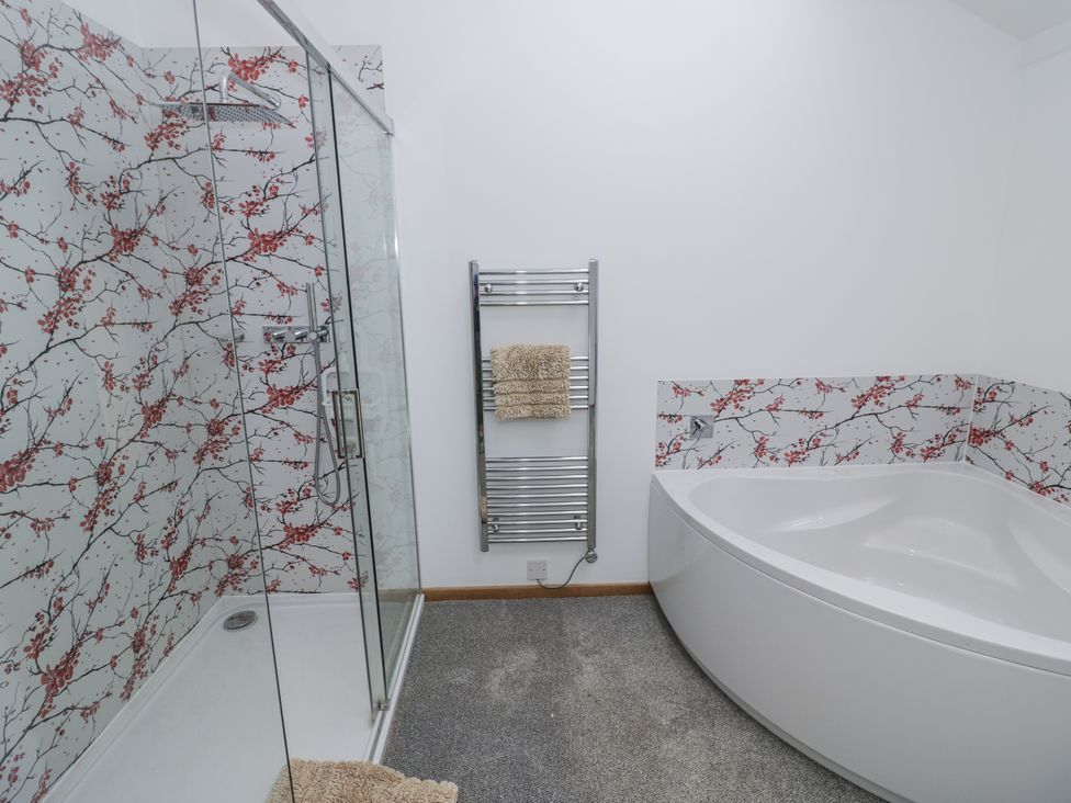 A bathroom with a shower and bathtub at Owl Barn in Banbury