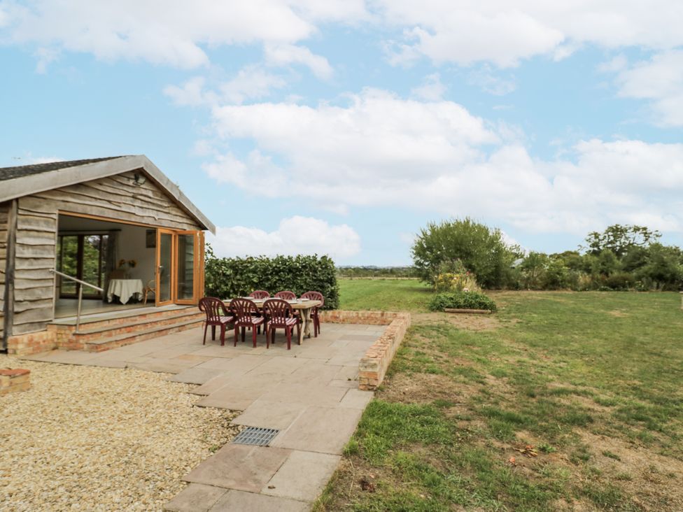 An outdoor seating area with a table and chairs at Owl Barn in Banbury