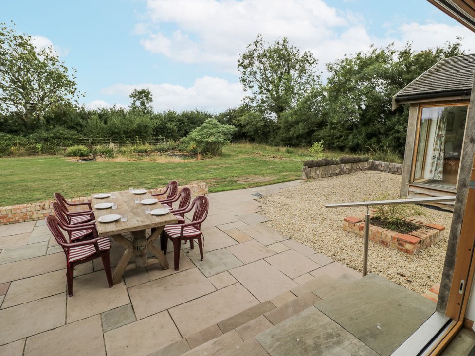 An outdoor patio with a dining table and chairs at Owl Barn Banbury