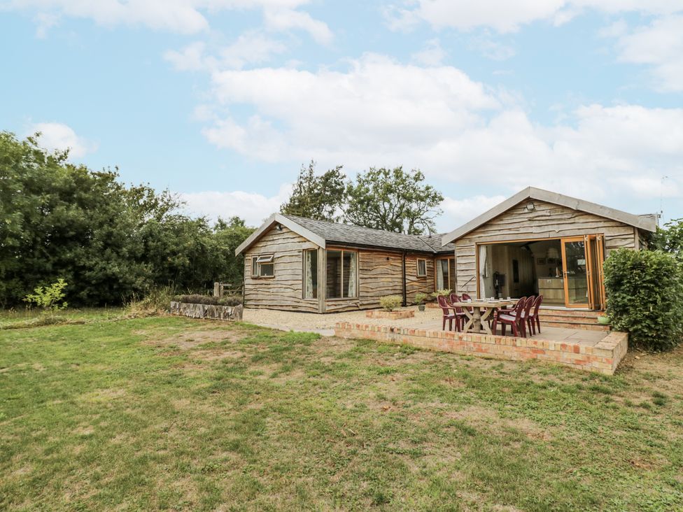 An outdoor view of a house with a table and chairs at Owl Barn in Banbury