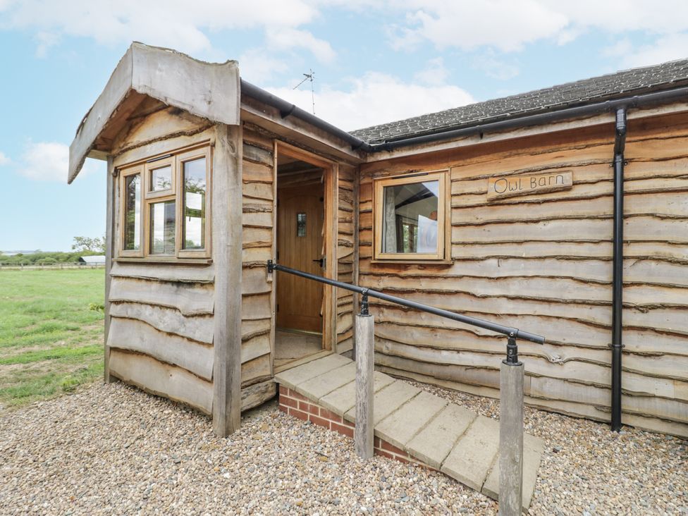 Exterior view of a wooden building with a sign at Owl Barn in Banbury