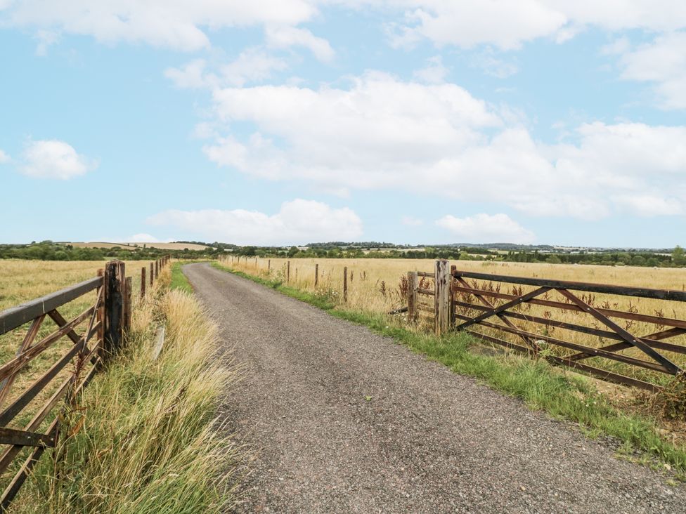 A gravel road between two wooden gates at Owl Barn in Banbury