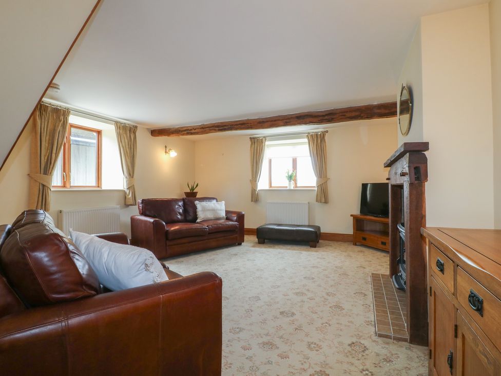 A living room with sofas and a television at Carr House Farm in Waberthwaite