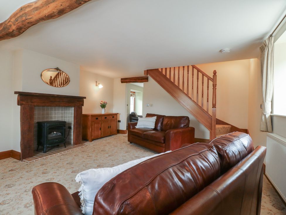 A living room with a sofa and fireplace at Carr House Farm in Waberthwaite
