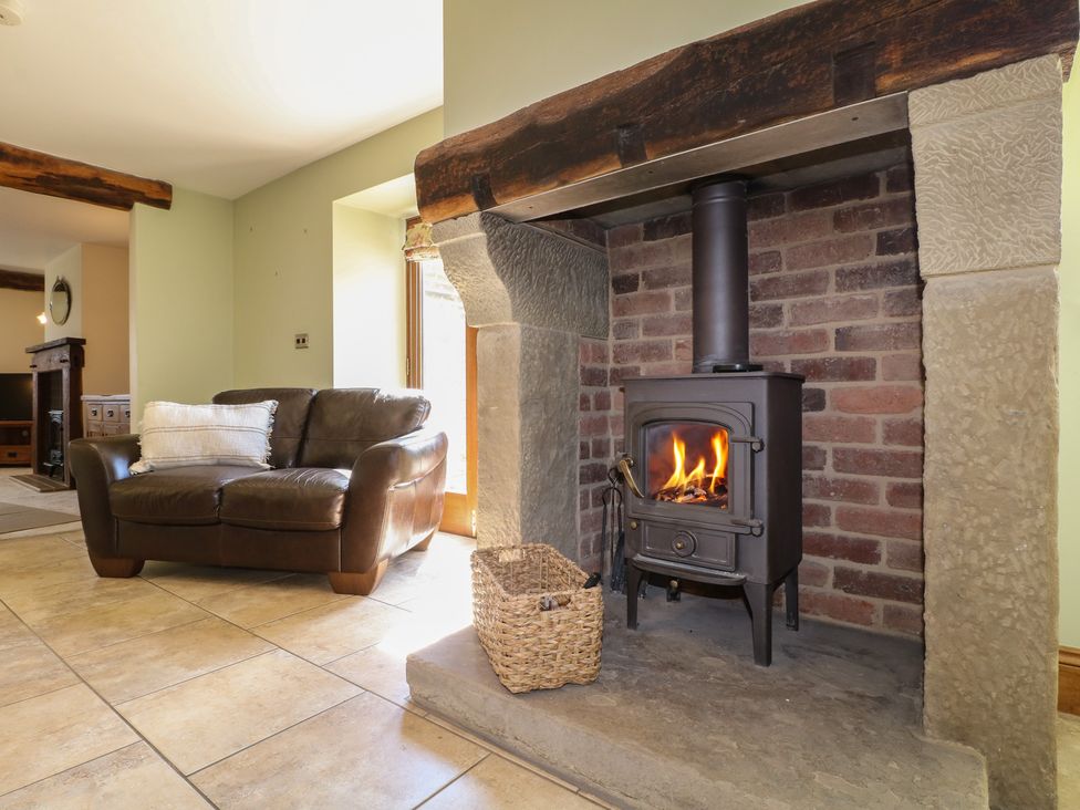 A living room with a stove and a sofa at Carr House Farm in Waberthwaite