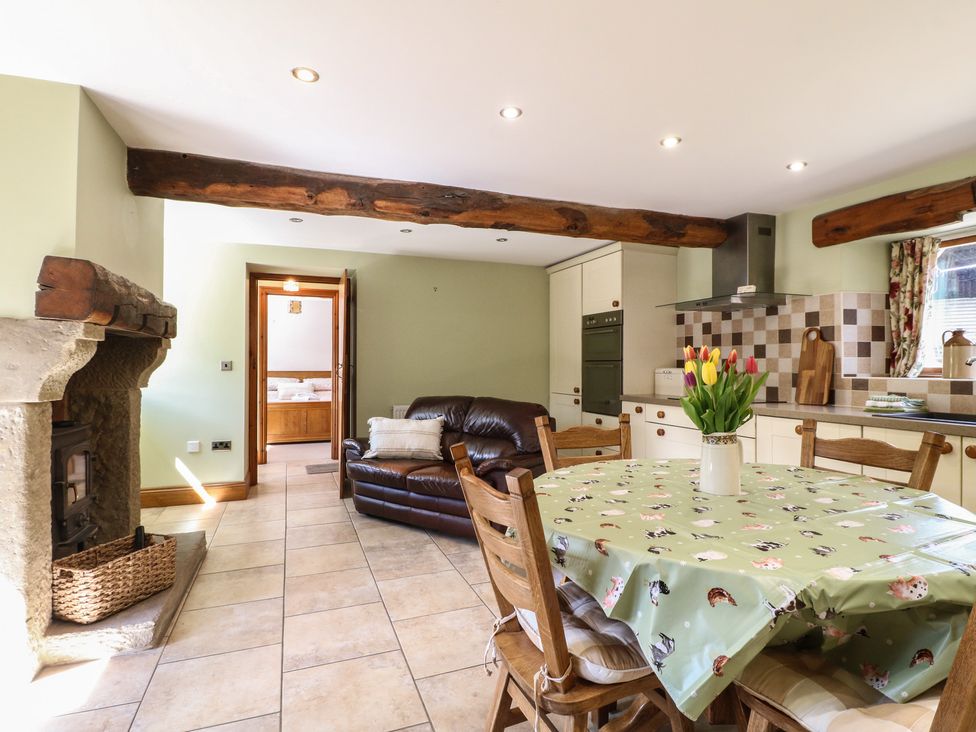 A kitchen with a table and chairs, and a sofa at Carr House Farm in Waberthwaite
