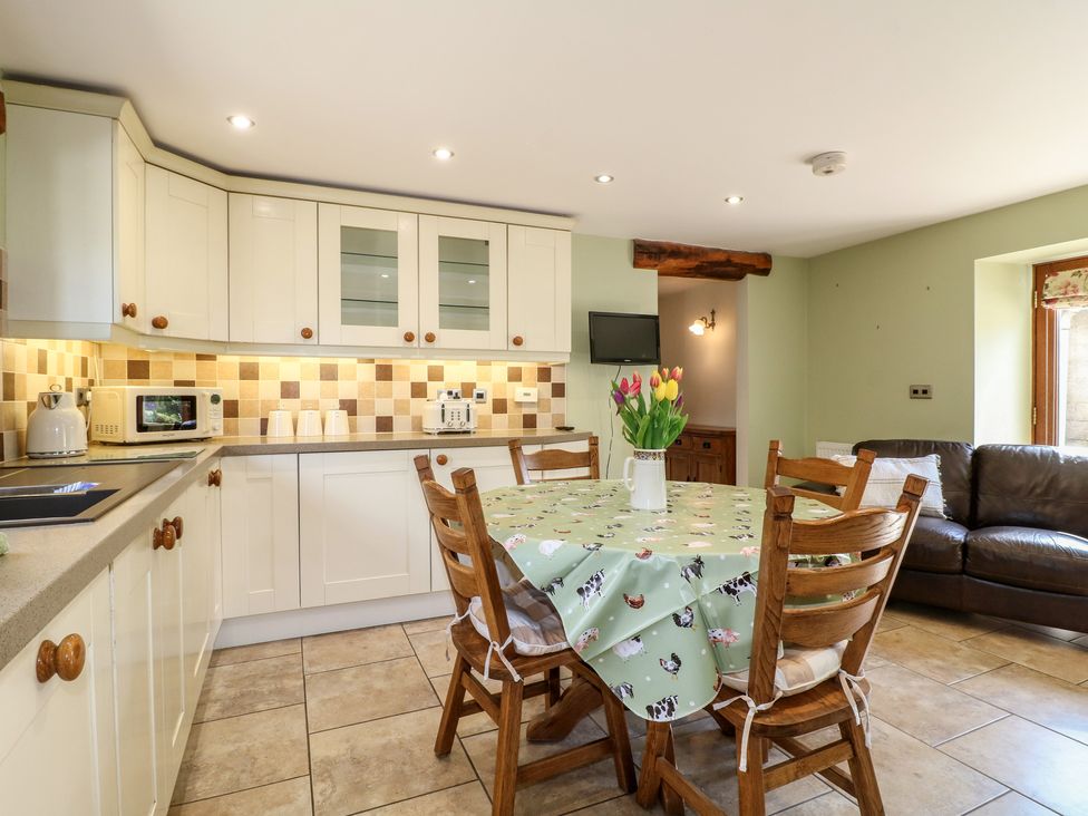A kitchen with a table and chairs at Carr House Farm Waberthwaite