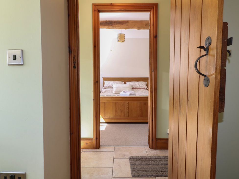A bedroom with a bed and towel on a bedside table at Carr House Farm in Waberthwaite