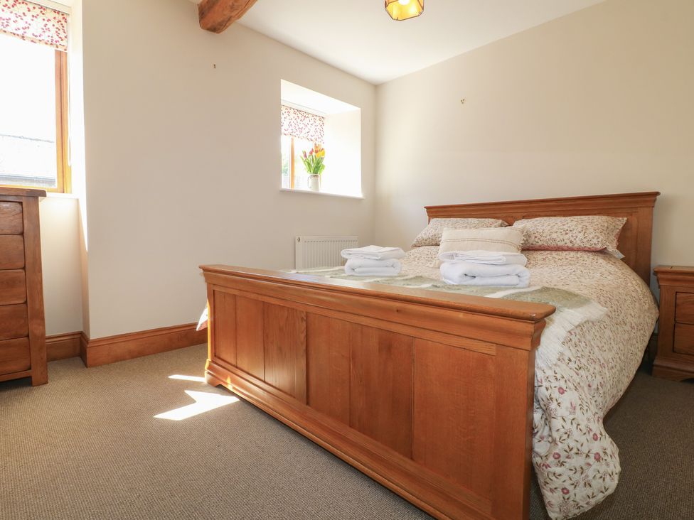A bedroom with a bed and dresser at Carr House Farm in Waberthwaite