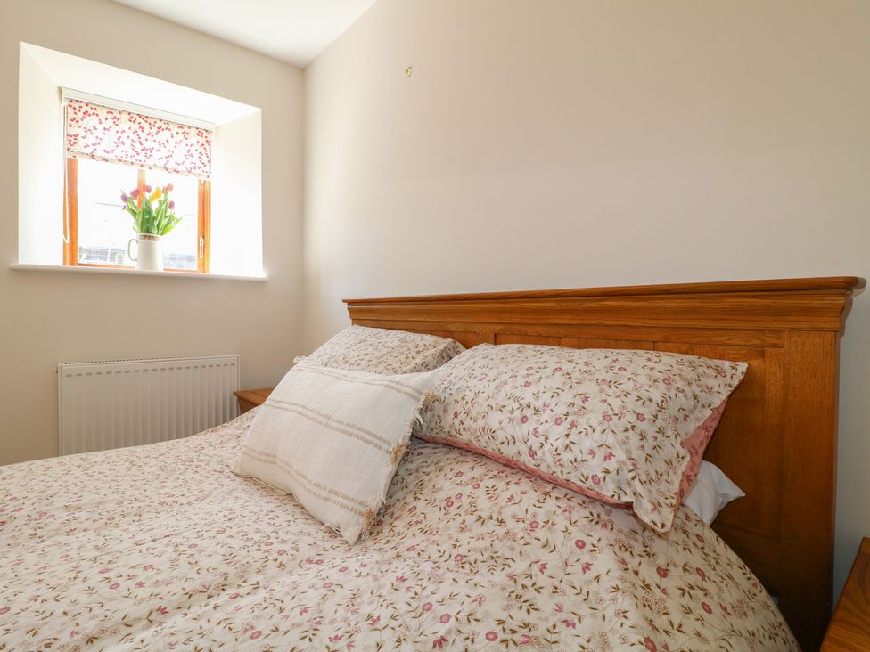 A bedroom with a bed and window at Carr House Farm in Waberthwaite