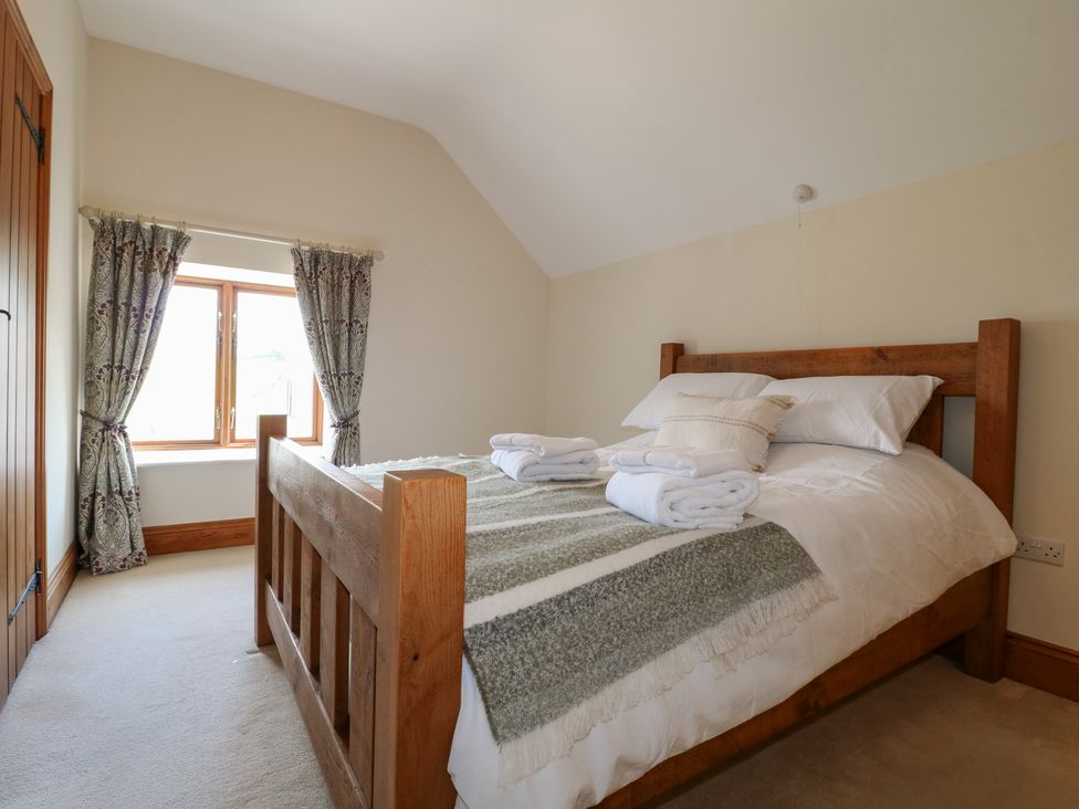 A bedroom with a bed and window at Carr House Farm in Waberthwaite