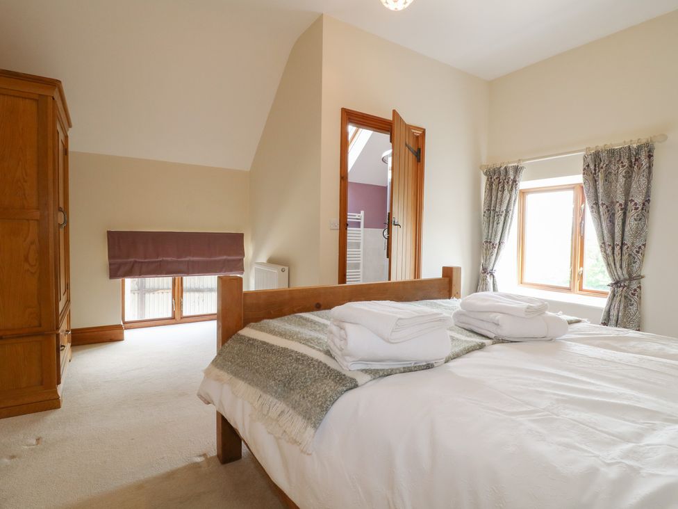A bedroom with a bed and wardrobe at Carr House Farm Waberthwaite