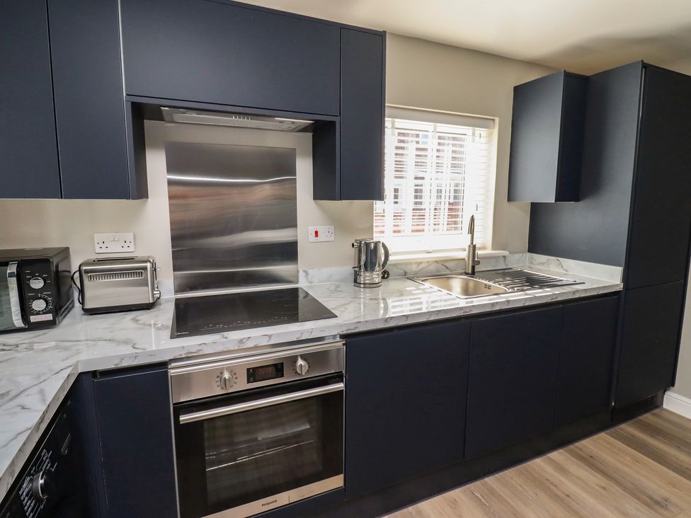 A kitchen with cabinets, sink, and appliances at 3 Longstone Park Beadnell