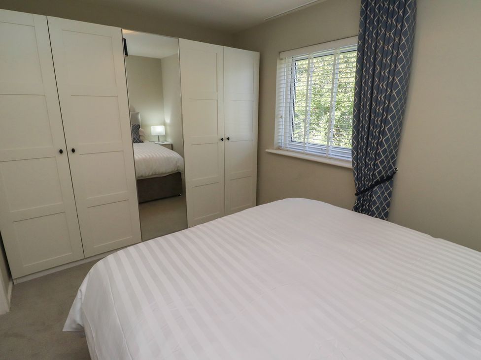 A bedroom with a bed and wardrobe at 3 Longstone Park Beadnell