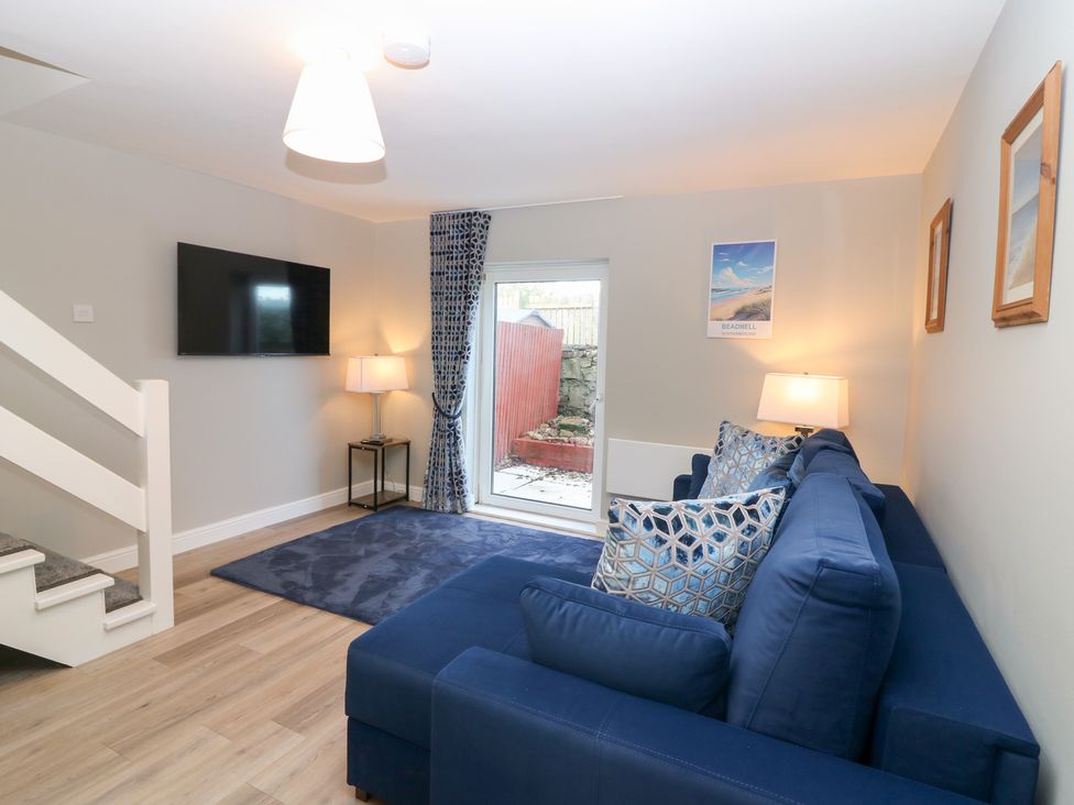 A living room with a sofa and television at Seaspray in Beadnell