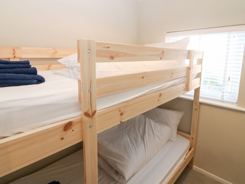 A bunk bed with blue towels and pillows at Seaspray in Beadnell