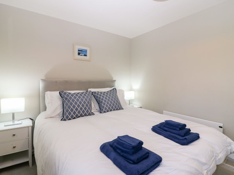 A bedroom with a bed and lamps at Seaspray in Beadnell