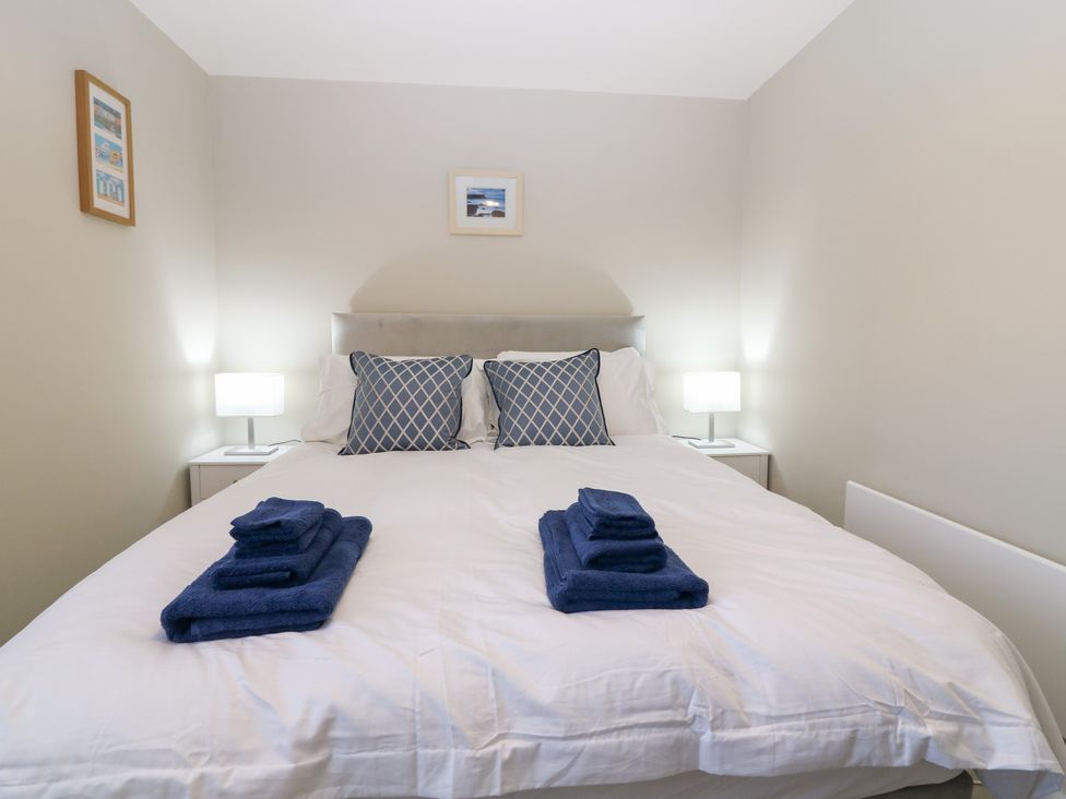 A bedroom with a bed and towels on top at Seaspray in Beadnell
