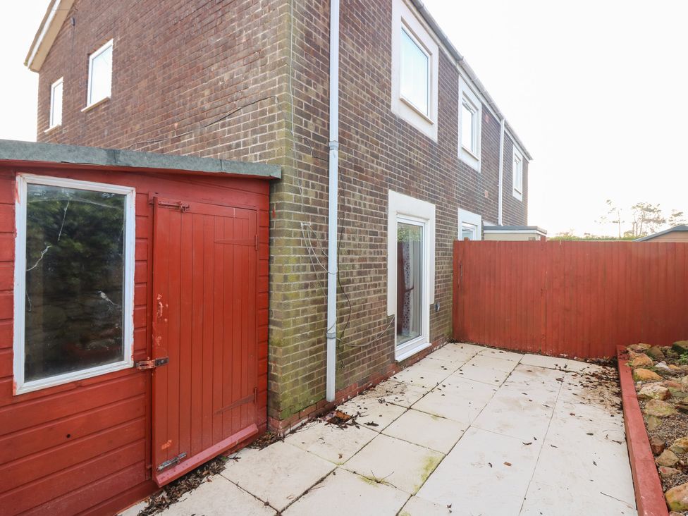 A red shed and patio area at Seaspray in Beadnell