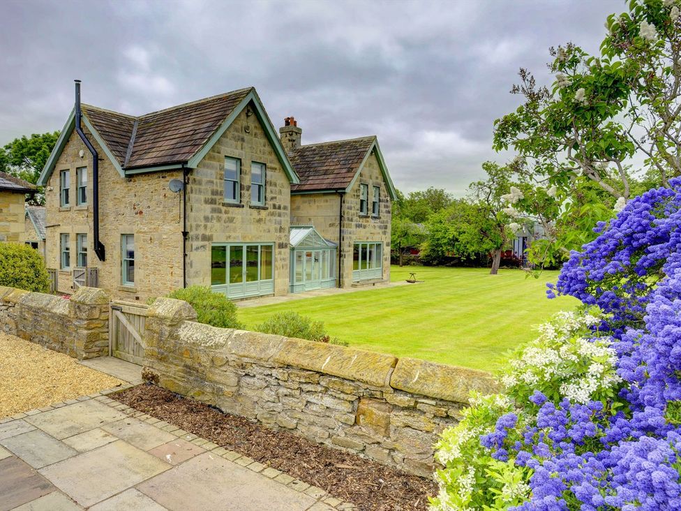 A house with garden and stone wall at The Farm House in Aldbrough St. John near Barton