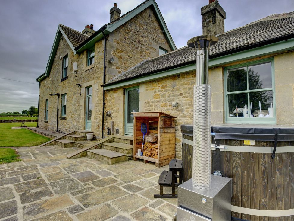 A garden with a hot tub and storage shed at The Farm House in Aldbrough St. John near Barton