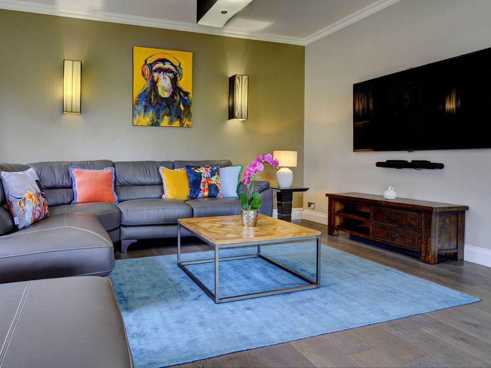 A living room with a sofa, coffee table, TV and artwork at The Farm House in Aldbrough St. John near Barton