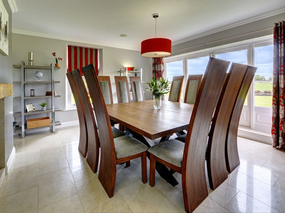 A dining room with a large table and chairs at The Farm House in Aldbrough St. John near Barton