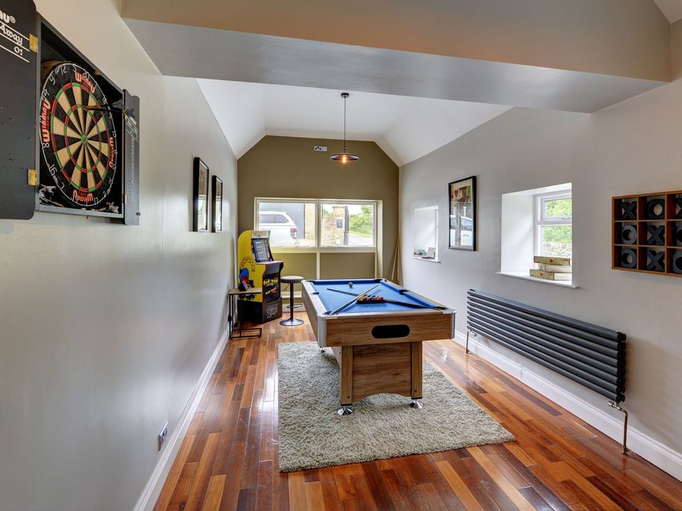 A games room featuring a pool table, dartboard, and arcade game at The Farm House in Aldbrough St. John near Barton