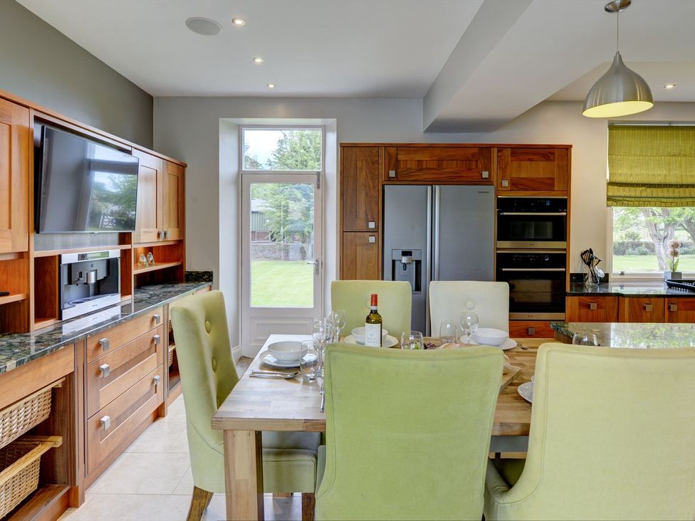A kitchen with a dining table and chairs at The Farm House near Aldbrough St. John