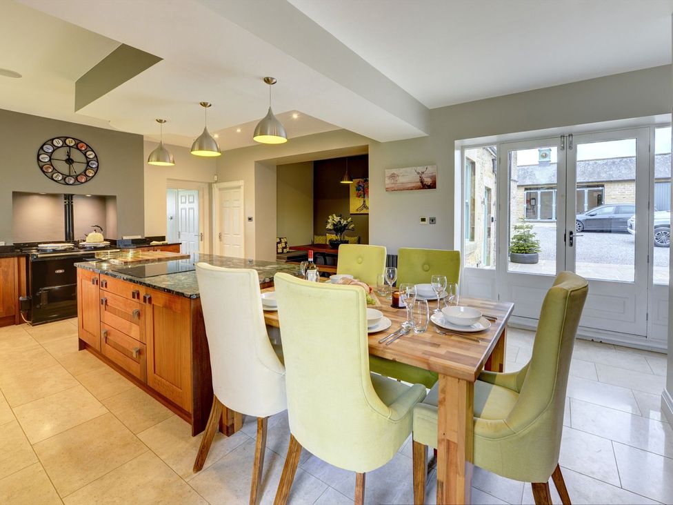A kitchen with a wooden dining table and chairs at The Farm House in Aldbrough St. John near Barton