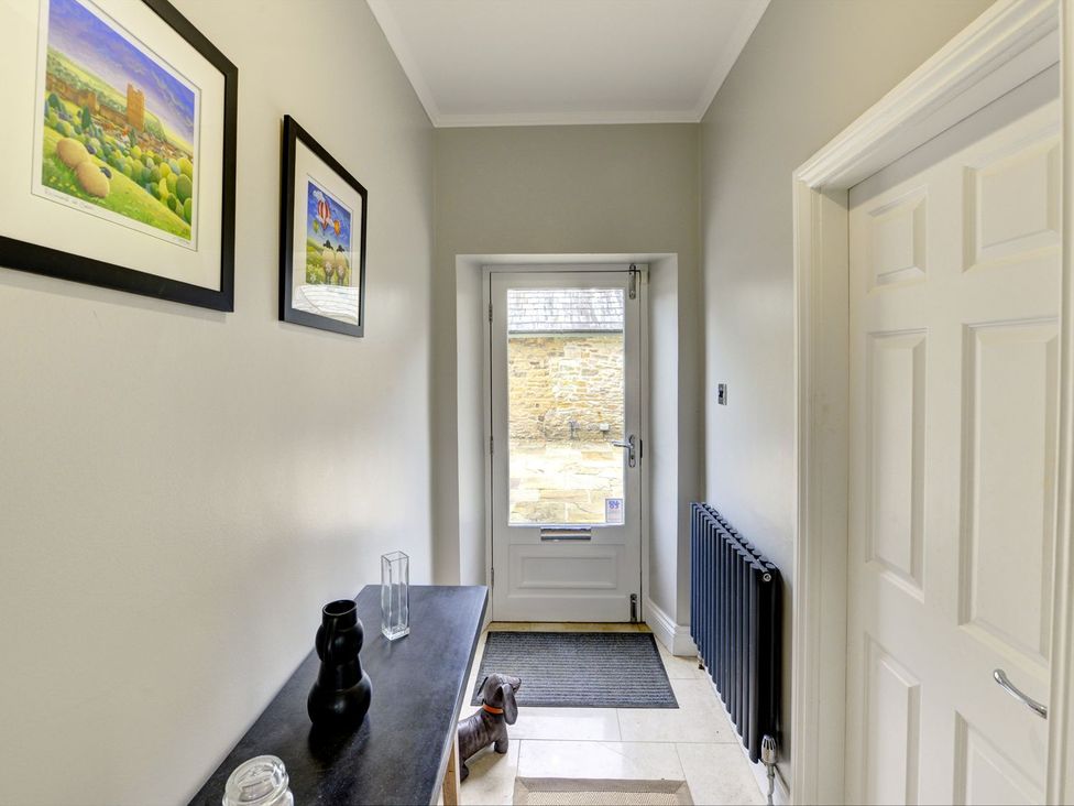 A hallway with a door and artwork at The Farm House in Aldbrough St. John near Barton