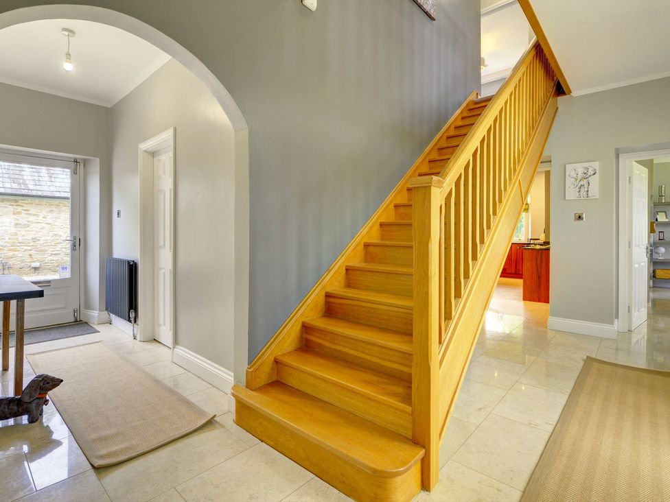 A hallway with stairs and a table at The Farm House in Aldbrough St. John near Barton