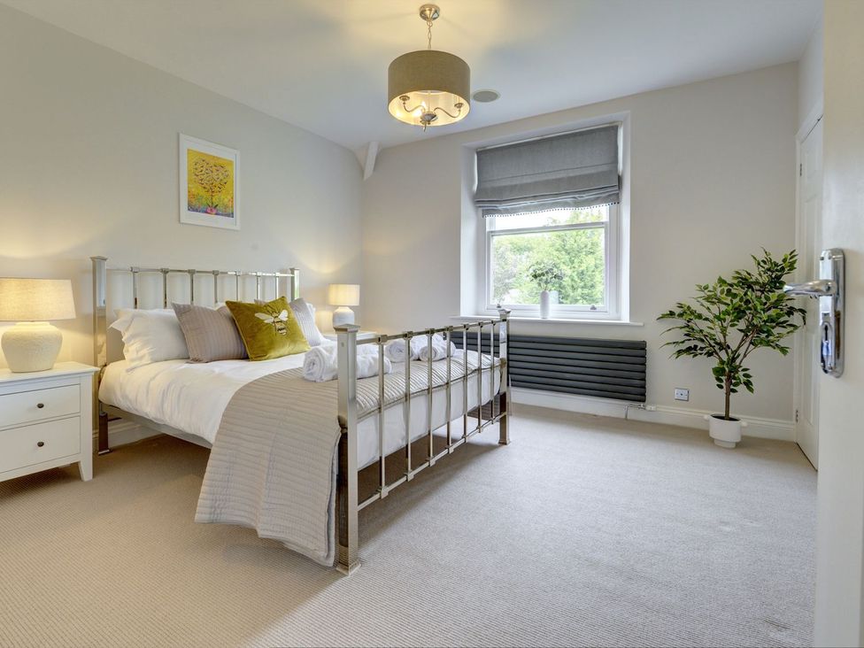 A bedroom with a bed and bedside table at The Farm House in Aldbrough St. John near Barton