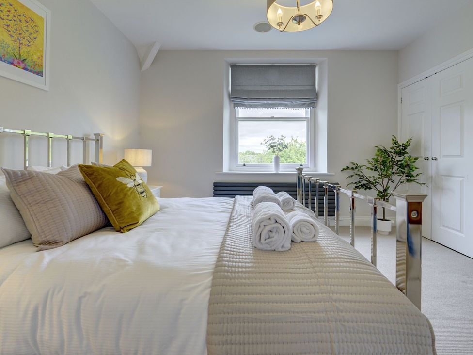 A bedroom with a bed and window at The Farm House Aldbrough St. John near Barton