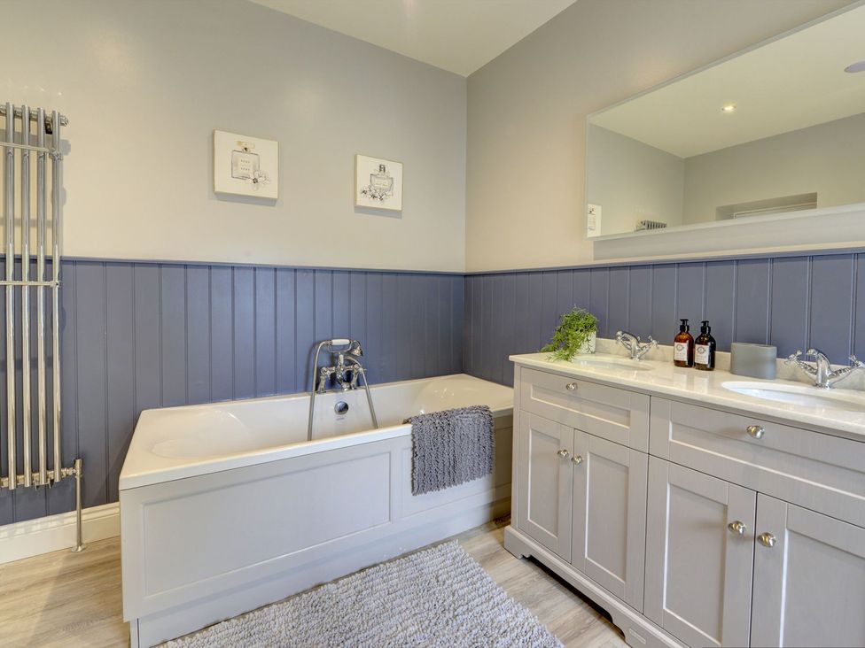 A bathroom with a bathtub and vanity at The Farm House in Aldbrough St. John near Barton