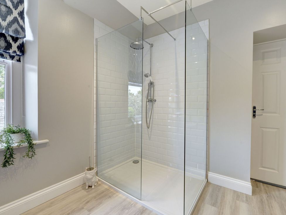 A shower with glass partition and wall tiles at The Farm House in Aldbrough St. John near Barton