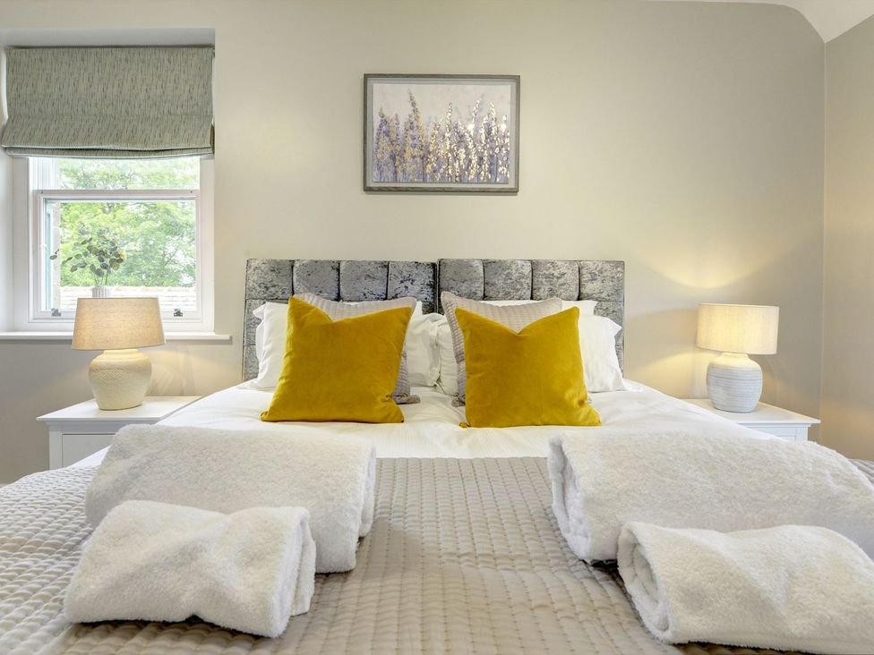 A bedroom with a bed and lamps at The Farm House near Aldbrough St. John
