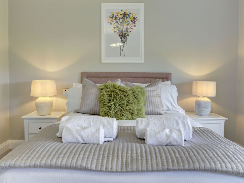 A bedroom with a bed and bedside lamps at The Farm House in Aldbrough St. John near Barton