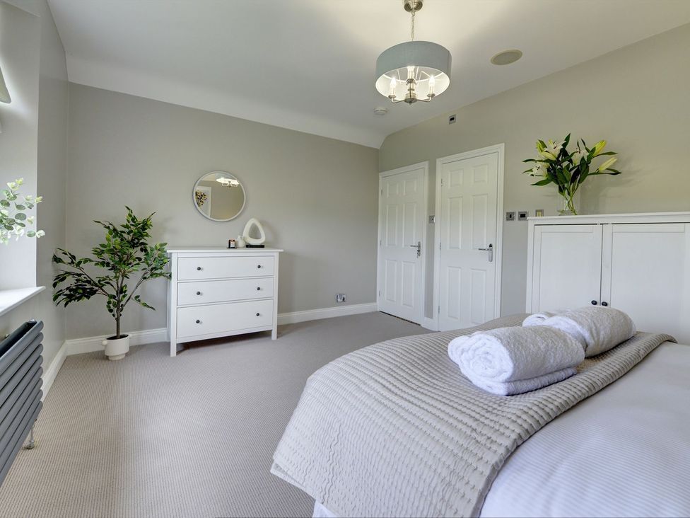 A bedroom with a dresser and a plant at The Farm House in Aldbrough St. John near Barton