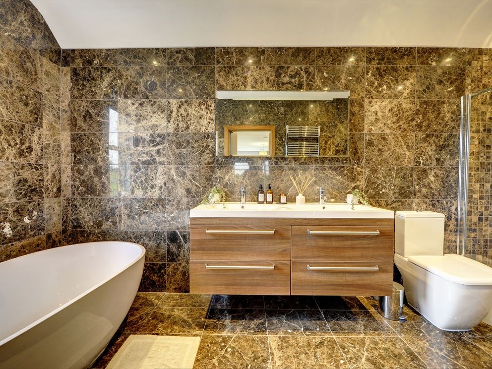 A bathroom with a bathtub, toilet, and sink at The Farm House in Aldbrough St. John near Barton