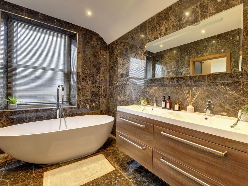 A bathroom with a bathtub and sinks at The Farm House in Aldbrough St. John near Barton