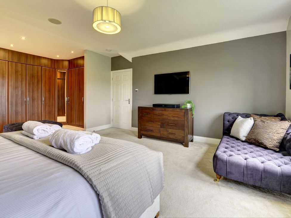A bedroom with a bed and wardrobe at The Farm House in Aldbrough St. John near Barton