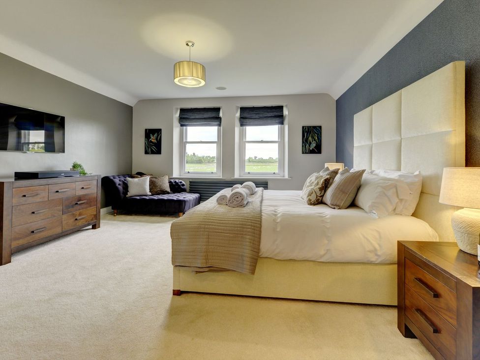 A bedroom with a bed and a sofa at The Farm House near Aldbrough St. John near Barton