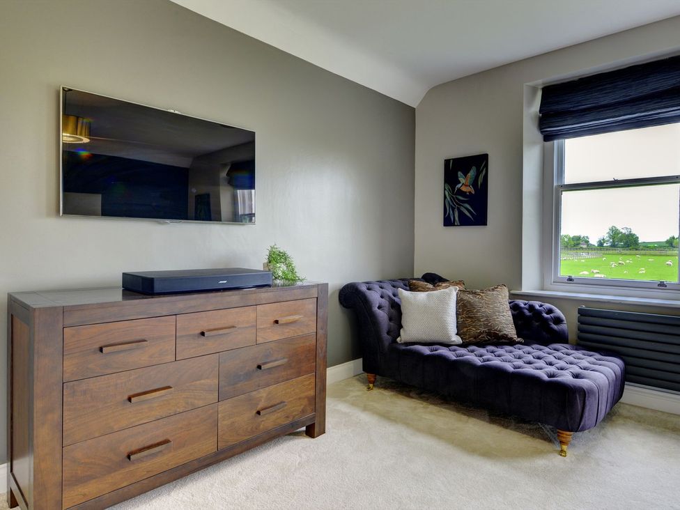 A living room with a television and a chest of drawers at The Farm House near Aldbrough St. John