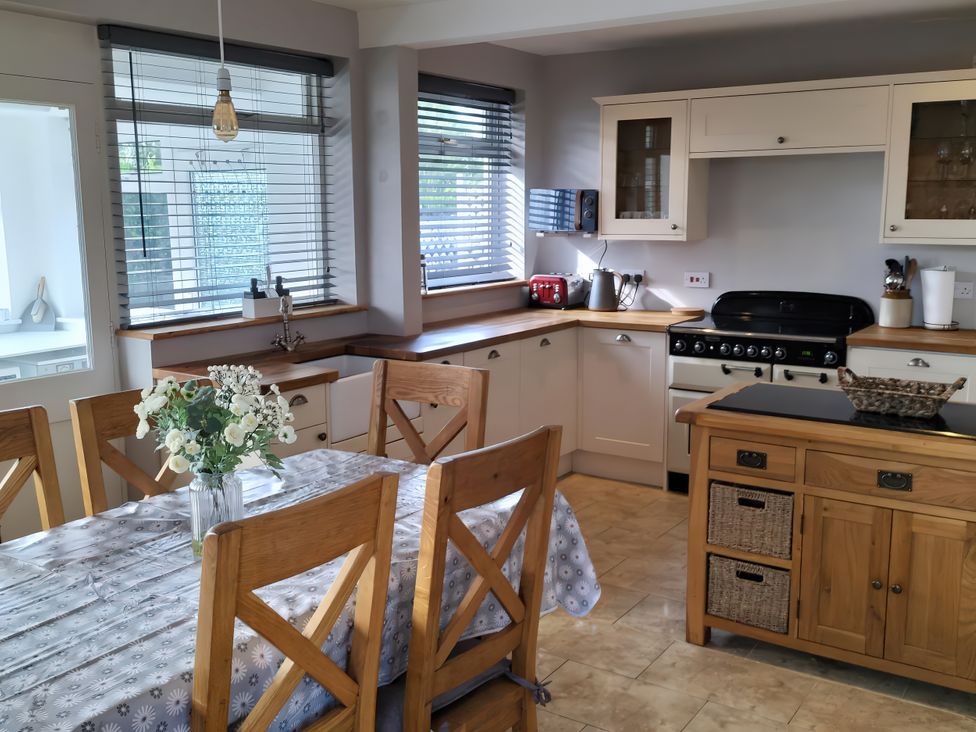 A kitchen with a dining table and chairs at 1 Maes Y Ffynnon Menai Bridge