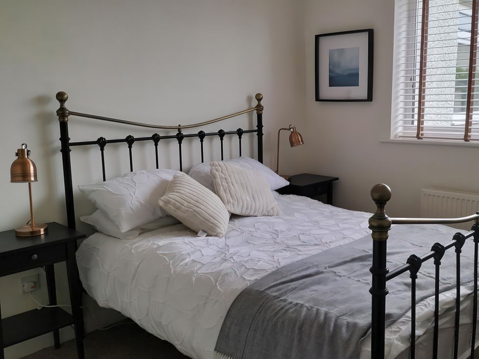 A bedroom with a bed and lamps at 1 Maes Y Ffynnon in Menai Bridge