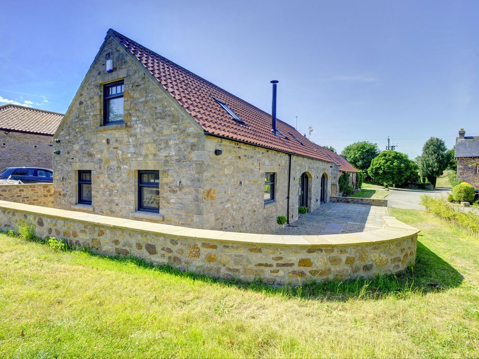 A stone house with a pathway and garden at The Gate House in Aldbrough St. John near Barton