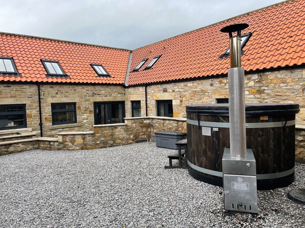 An outdoor area with a hot tub and gravel surface at The Gate House in Aldbrough St. John near Barton