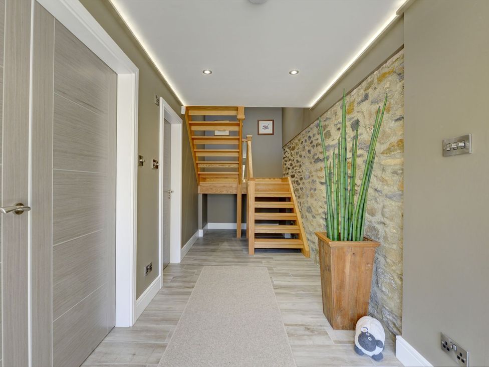 A hallway with stairs and a potted plant at The Gate House in Aldbrough St. John near Barton